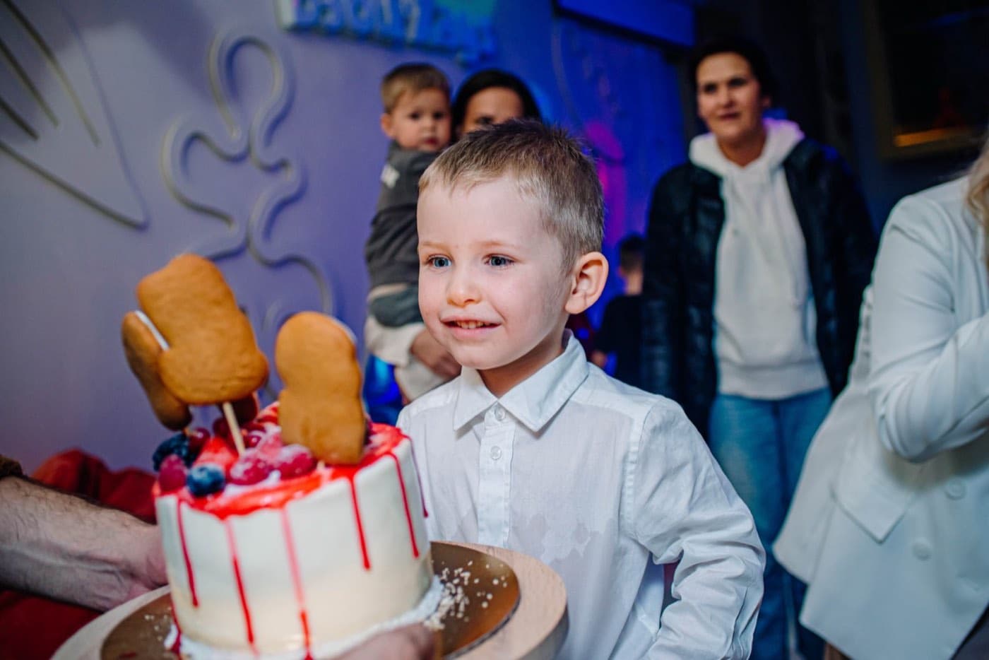 Пятилетний мальчик задувает свечи на торте